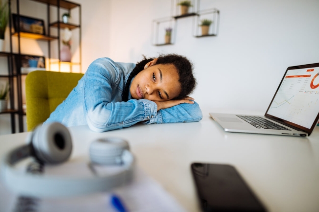 African-American Gen-Z college student taking a break from studying at home