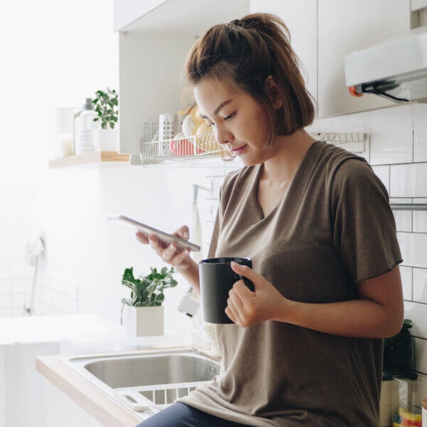 Woman working on phone while at home