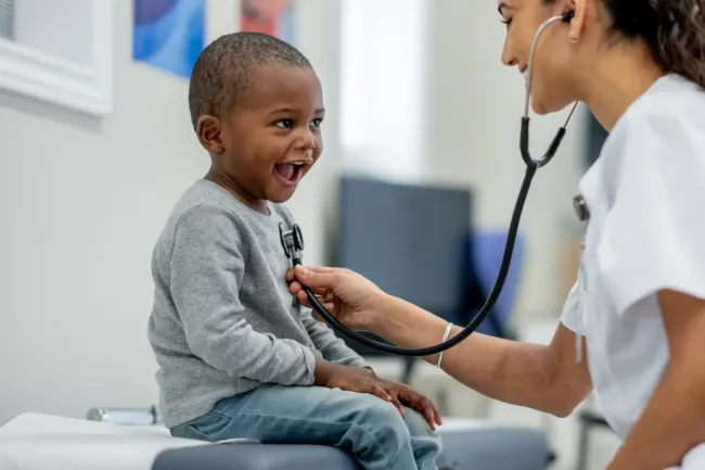 A young boy getting his heart checked by a nurse
