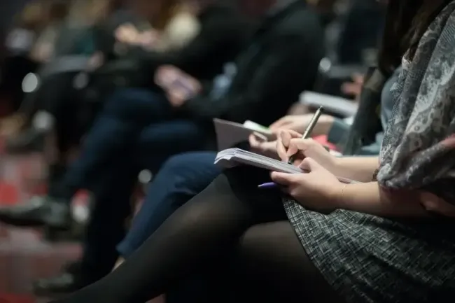 woman writing at customer experience conference
