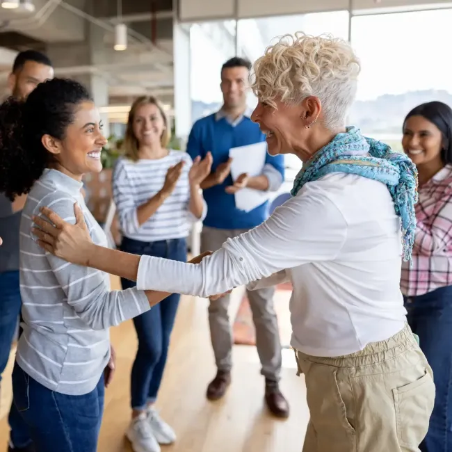 Employees celebrate a woman in an office