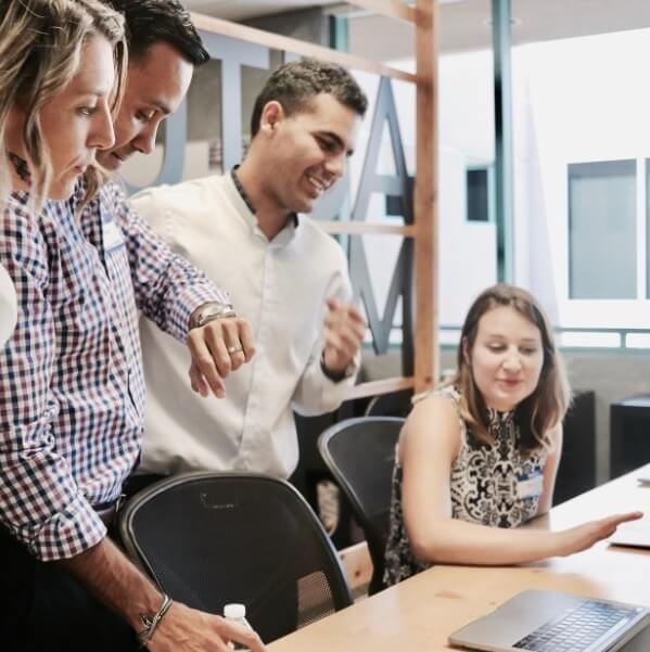Employees gathering together around a computer