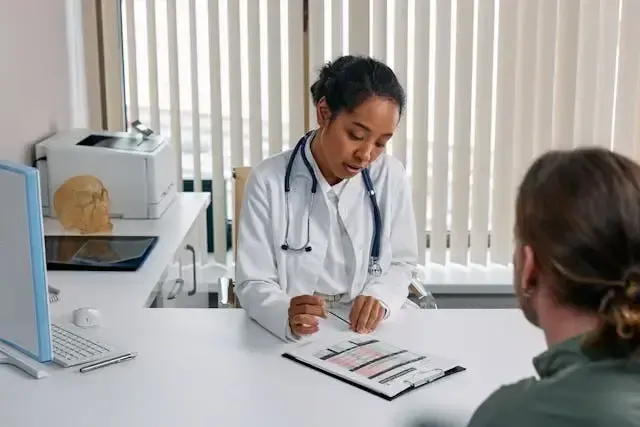 Doctor looking a patient experience survey with patient