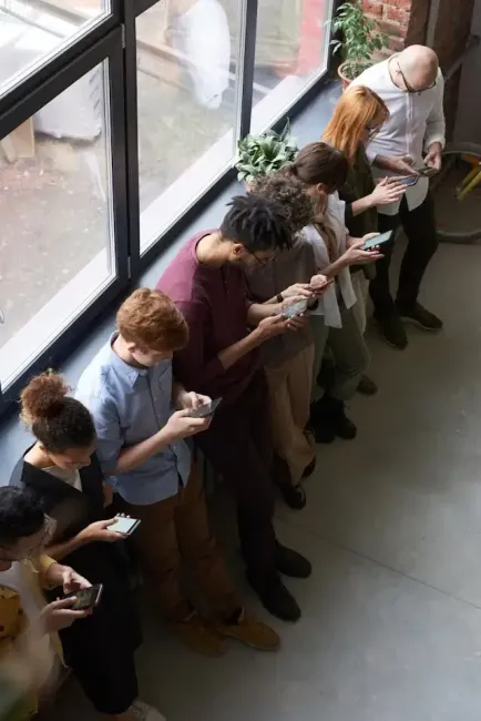 line of people immersed in social media on their phones