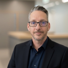 A headshot style photo of Dale Preston in business clothes