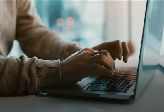 Person's hands typing on laptop keyboard