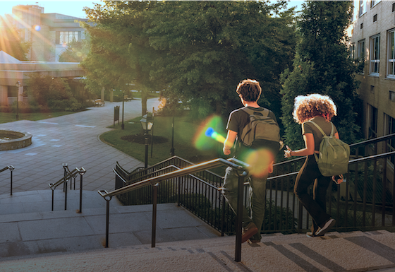 Children with backpacks running down stairs