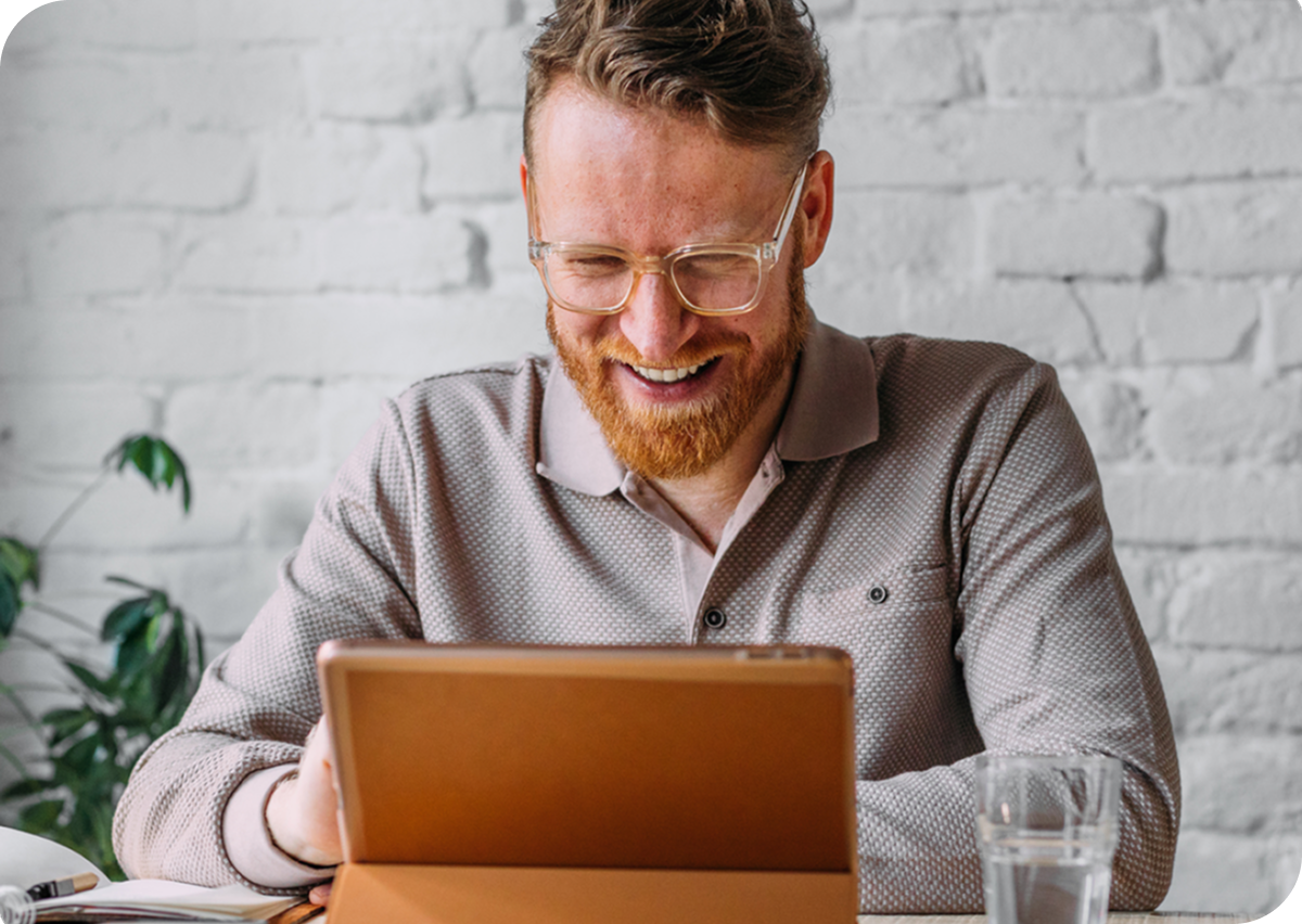 A man laughing at hit tablet
