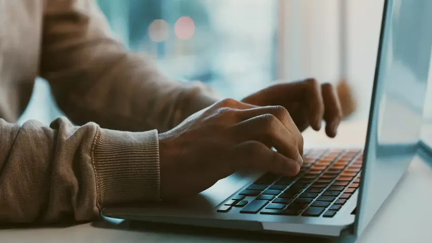 An image showing two hands typing on a keyboard.