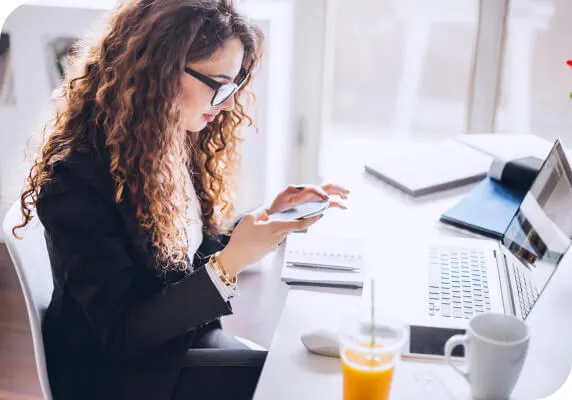 Woman working with phone and laptop